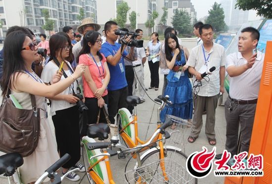 西線采訪團采訪了薛城區城市公共自行車服務系統，工作人員向記者們講解公共自行車的詳細情況。 記者 郭豪 攝。